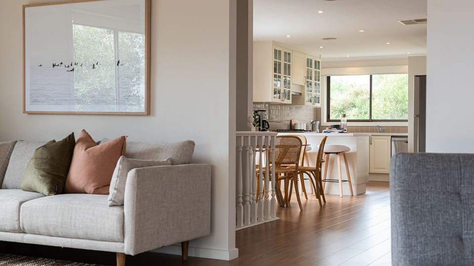 Comfy sofa with a peak of the kitchen and dining