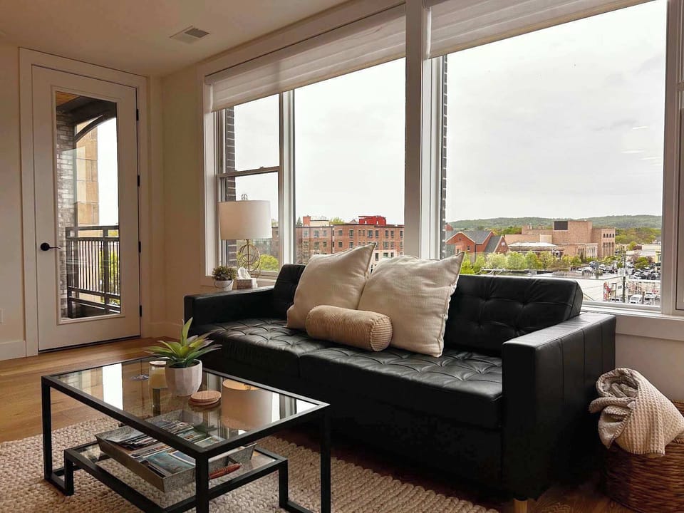 Modern lounge space with natural light and balcony access.