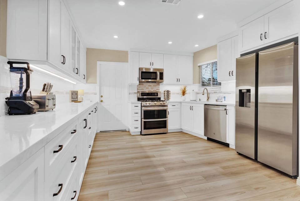 Seamless open concept kitchen with all new stainless appliances, including smart Samsung Fridge and Double Convection Oven.