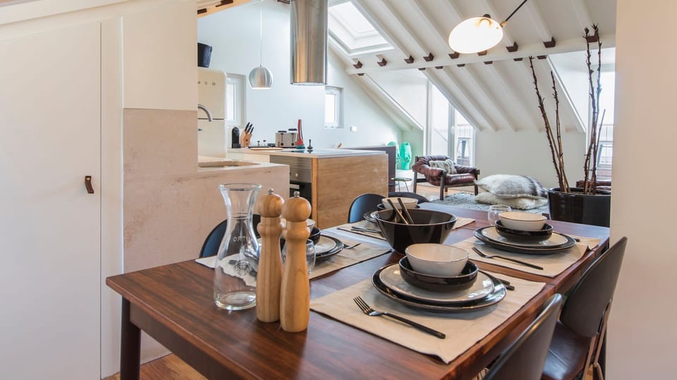 Gather around the dining table for memorable meals in this elegant open-plan space overlooking the cozy living area. #DiningArea #OpenPlanLiving #HomeAwayFromHome #TravelPortugal #Portugal #PT #Lisbon