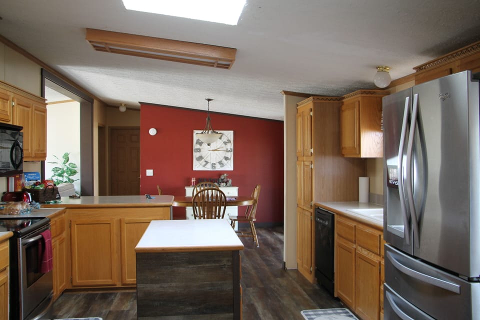 Kitchen with refrigerator,stove and  dishwasher and lots of pots and pants.