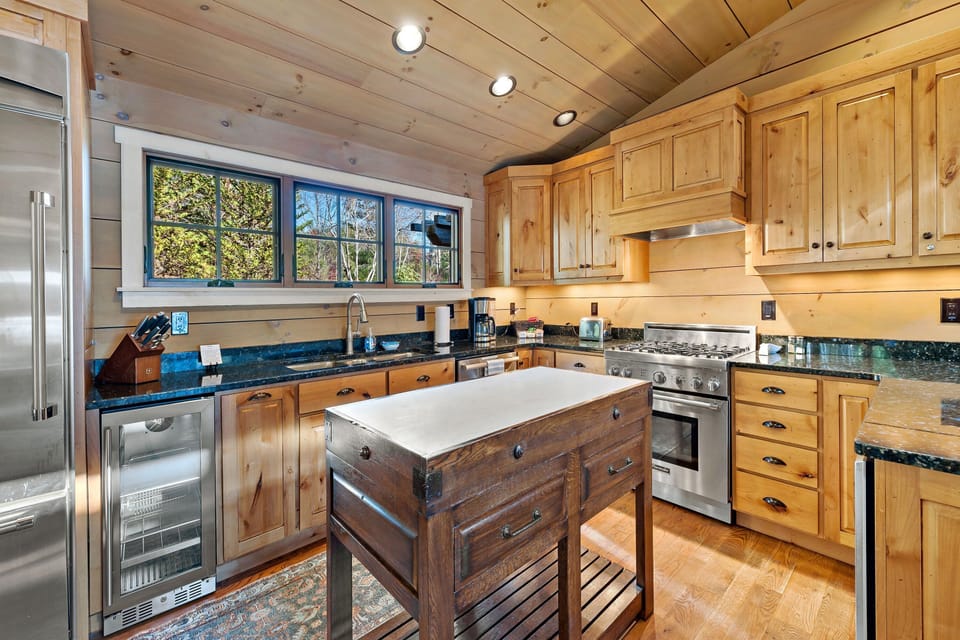 Fully equipped kitchen with wine cooler, gas range, dishwasher, and drip-style coffeemaker ready for family meals and lakeside feasts.