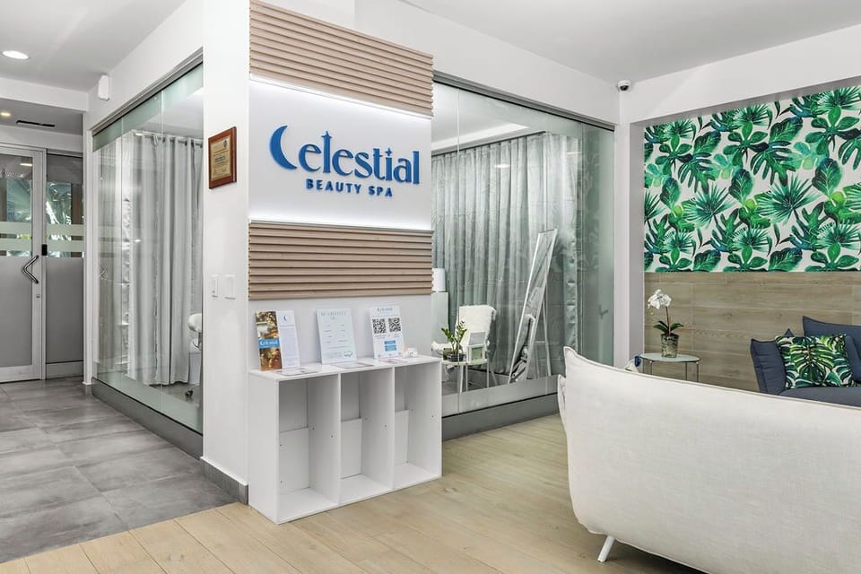 A welcoming spa lobby awaits you with vibrant tropical decor, a comfortable seating area, and branded signage—your gateway to relaxation and rejuvenation at this beauty spa facility.