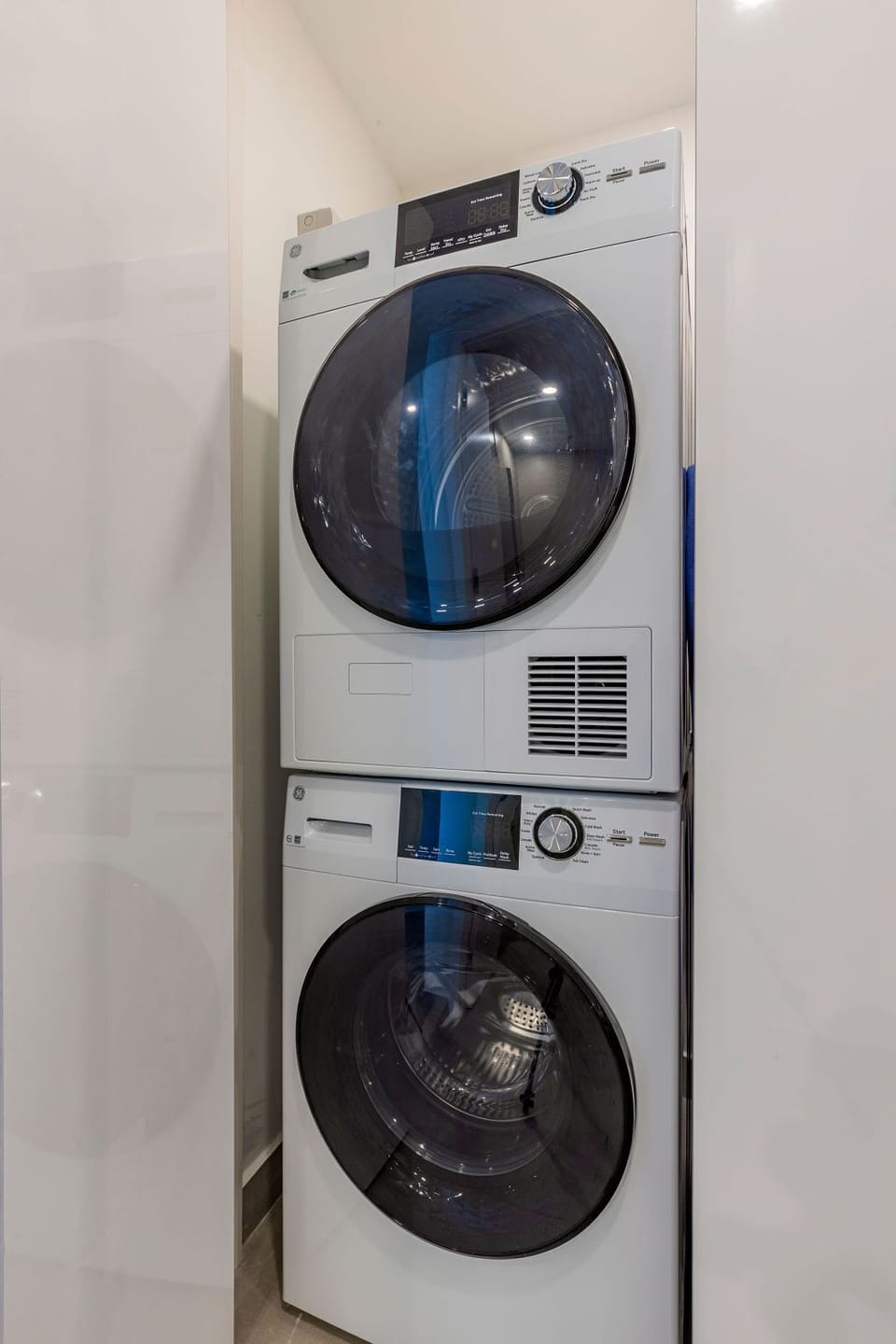 A dedicated laundry closet features a stacked washer and dryer, offering in-unit convenience for your comfort during your stay.