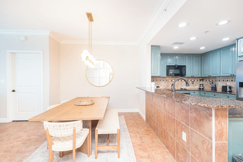 Your spacious open-plan kitchen flows into a welcoming dining space, where meals become memorable moments beneath warm lighting and coastal elegance.