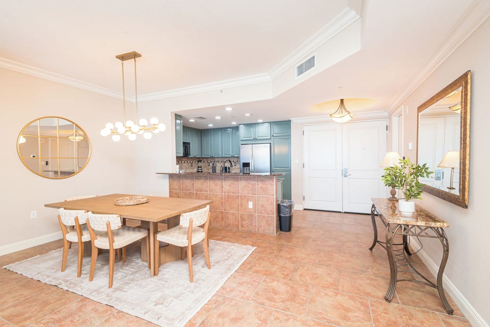Gather around the elegant dining table and enjoy your favorite meals in this open, inviting space with a fully equipped kitchen just steps away.