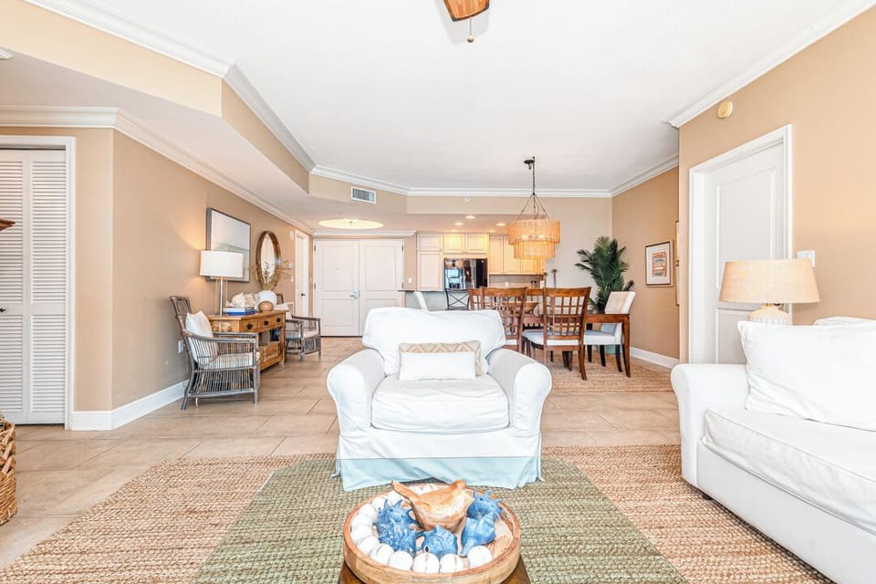 This bright, open-concept space invites you to settle into soft white sofas and soak up the coastal warmth, with easy flow from living to dining areas.