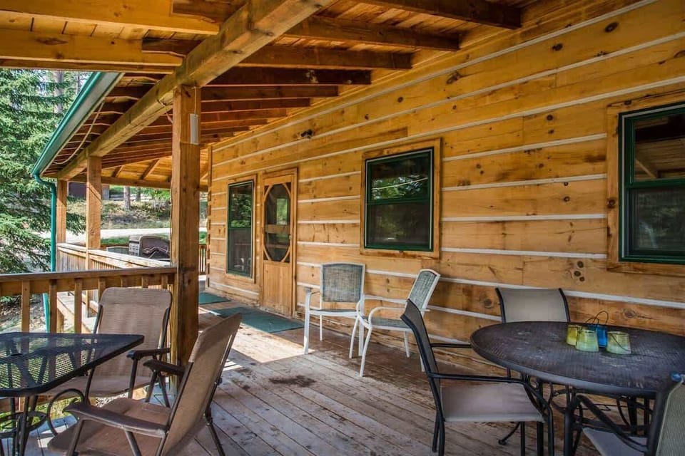 Main level deck, just off of the kitchen with a table and chairs and a gas BBQ grill