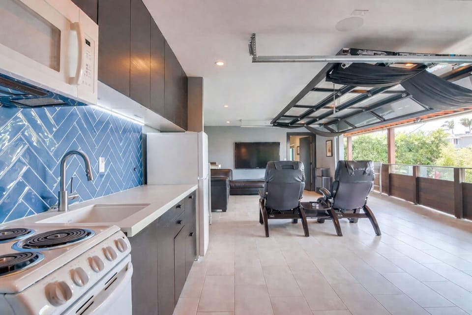 View of open concept kitchen leading into living room with garage open