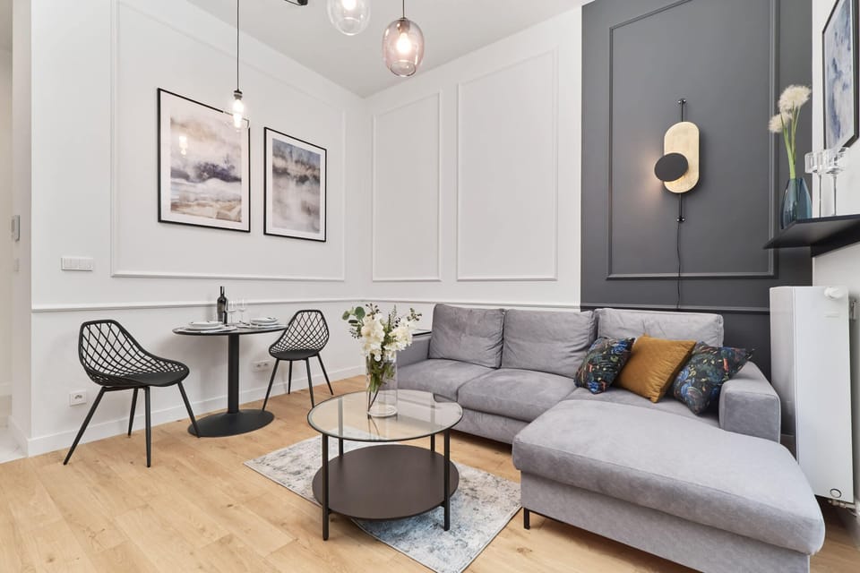 A cozy living area with a sofa, coffee table, and stylish wall decor.
