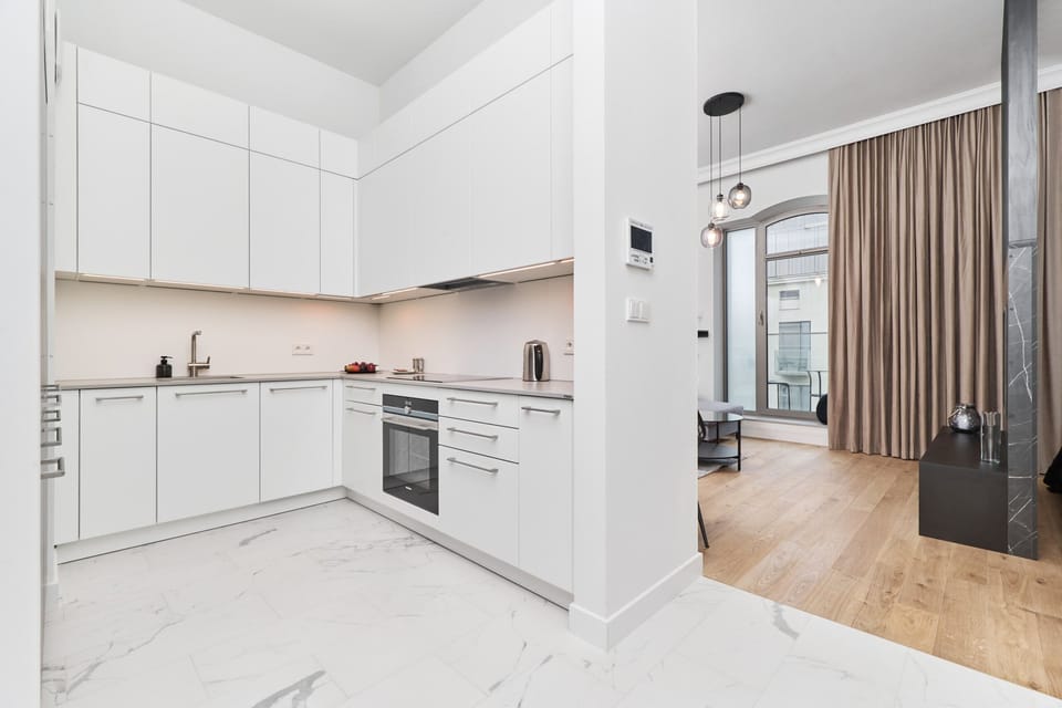 A compact kitchen with white cabinets, modern appliances, and a clean layout.
