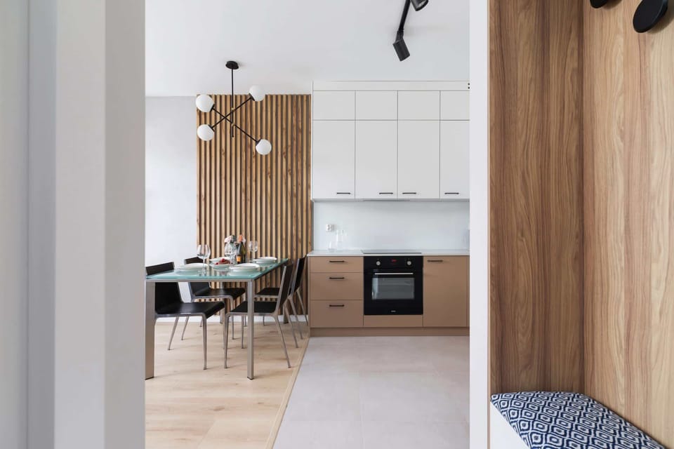 Bright space, view from hallway with upholstered seating to kitchenette.