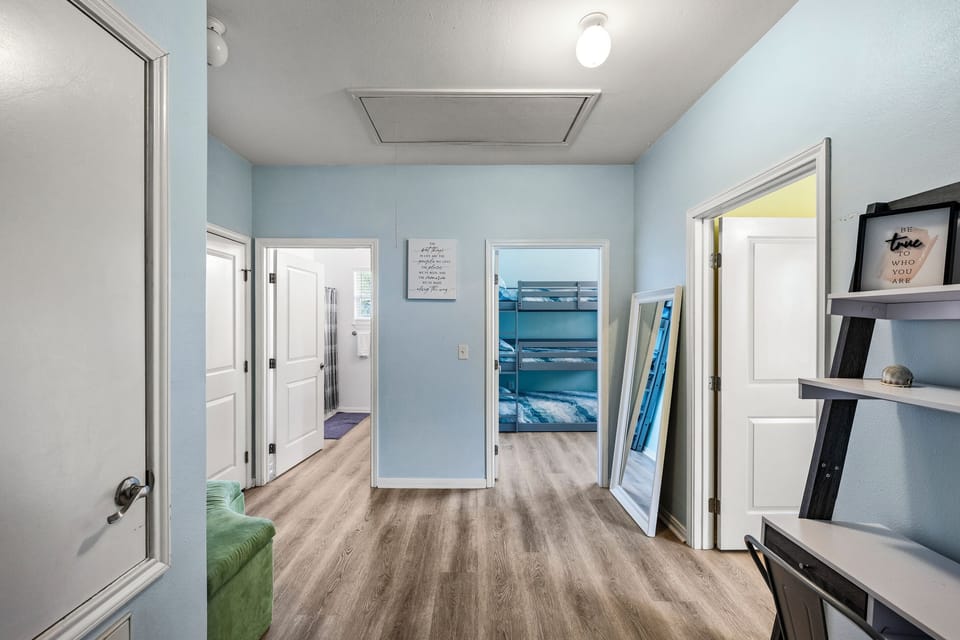 The upstairs landing at Summer Bliss — a bright foyer connecting Bedroom 2, Bedroom 3, and the guest bathroom, with a dedicated workstation for remote workers.