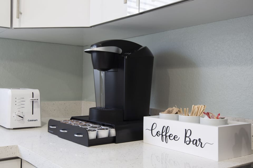 Keurig coffee machine with complimentary pods, sugar, and creamers