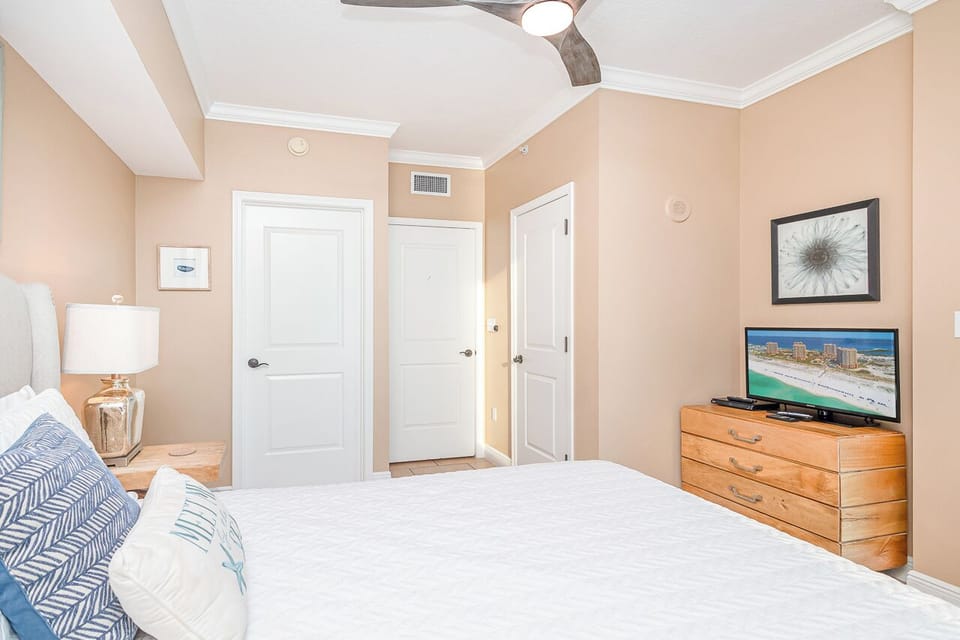 Sink into your coastal bedroom with cathedral ceiling, TV, and soothing beige tones for ultimate relaxation.