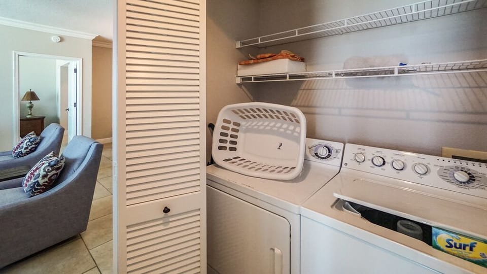 Your in-unit washer and dryer keep laundry effortless, with extra storage shelves for linens and beach gear above.