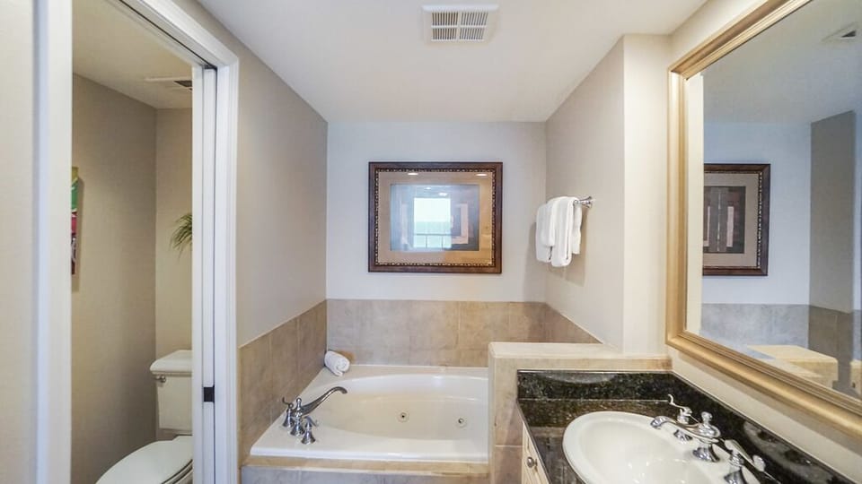 Step into your private spa-like bath featuring a deep soaking tub and warm, calming tones that invite you to unwind after a day of exploration.