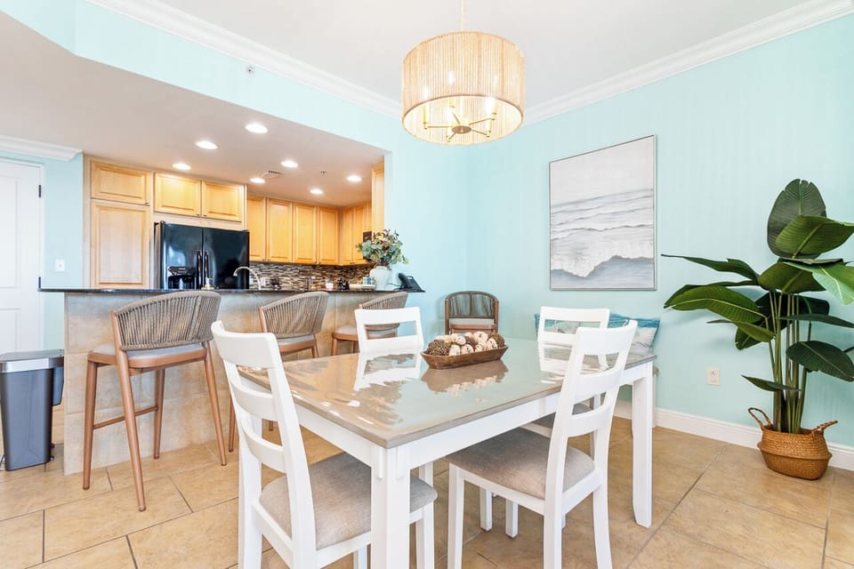 Your coastal dining space features warm wood tones and soft mint walls, creating the perfect spot for memorable meals together.