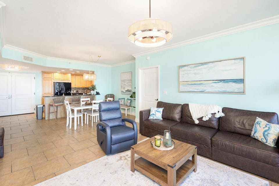 Sink into the plush leather sofa and unwind in your open-concept living space, where coastal blues and modern comfort create your perfect beach getaway.