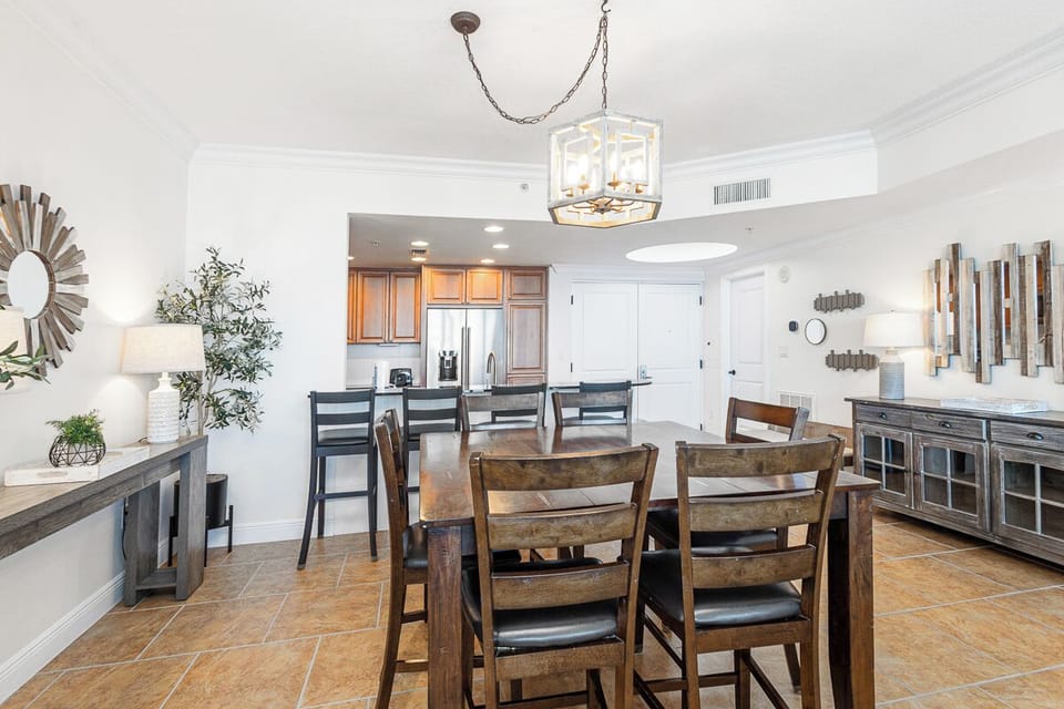 Gather around this inviting dining space where your group can share memorable meals together. The open layout flows seamlessly into the full kitchen, creating a warm hub for your vacation moments.