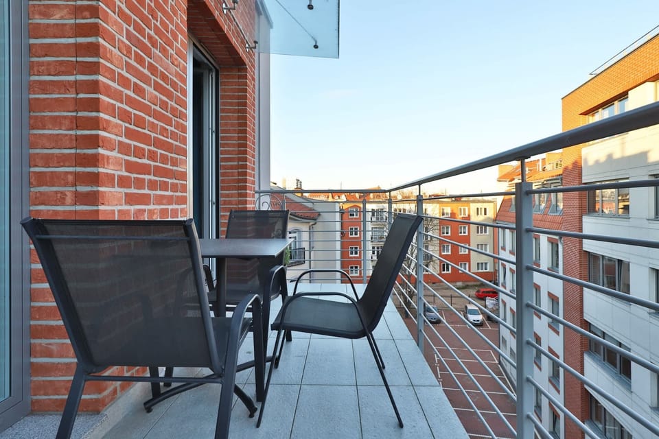 Contemporary balcony with a brick wall backdrop and modern railings. Offers privacy and urban charm.