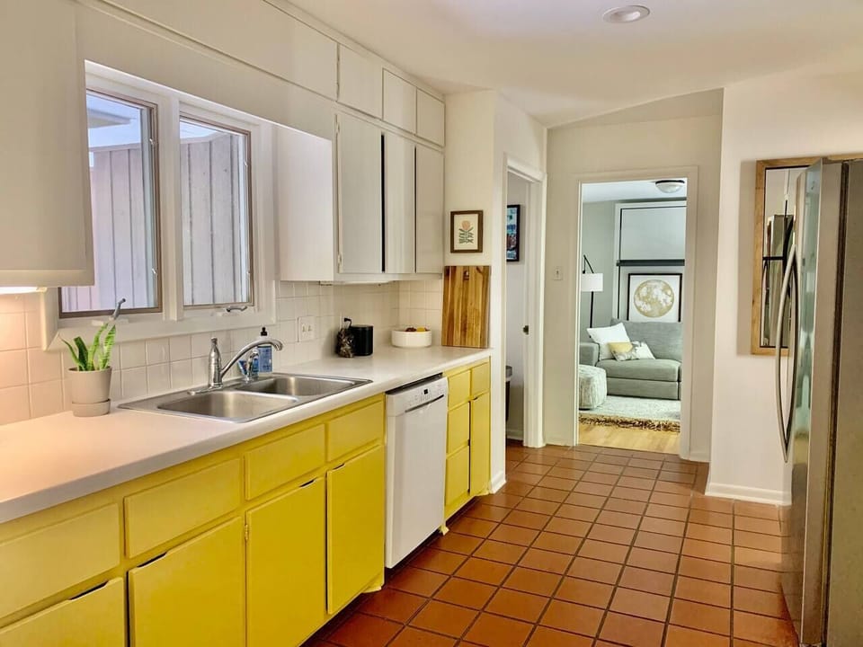 The mid-century galley kitchen has stainless steel fridge, gas range, and dishwasher. FULLY stocked kitchen for those who like to cook. Pots, pans, sharp knives, olive oil, spices, all kitchen tools, cast iron pans, food processor; we've got it all. 