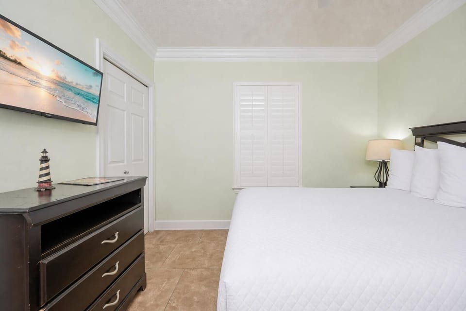 Unwind in this guest bedroom featuring a queen bed, soft linens, and a TV for your entertainment