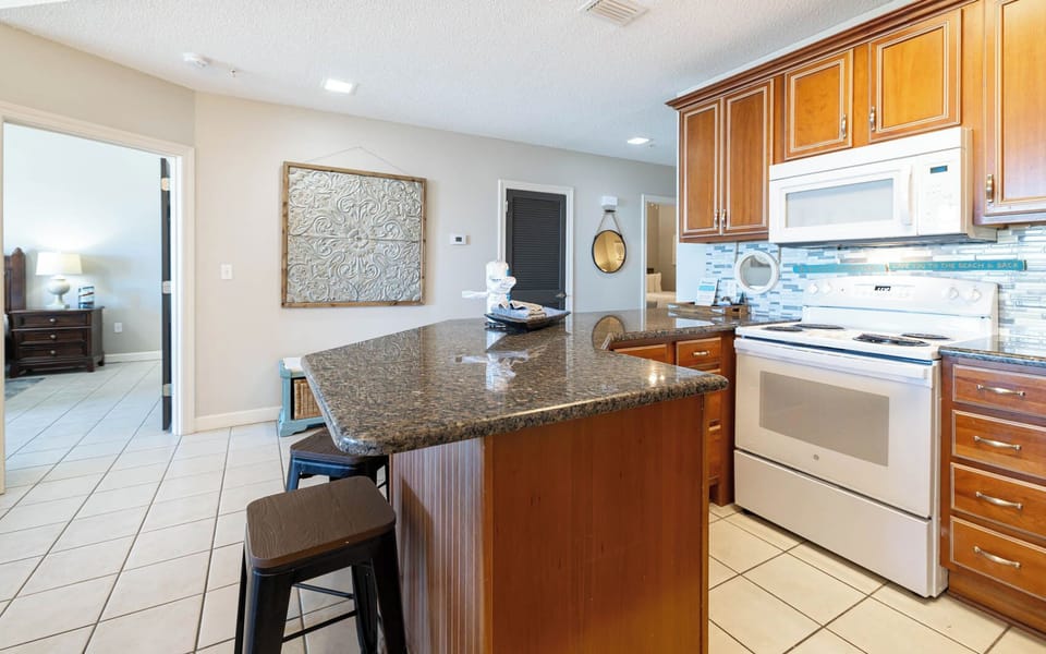Gather around the sleek granite counter, enjoying meals and conversations in this inviting kitchen space