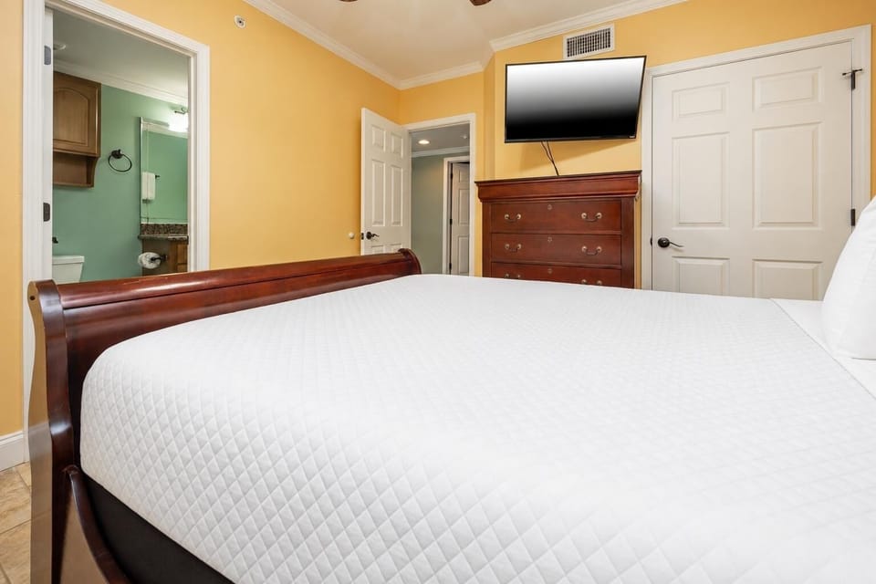 Relax in this guest bedroom featuring a comfortable queen bed, a TV, and easy access to a stylish bathroom