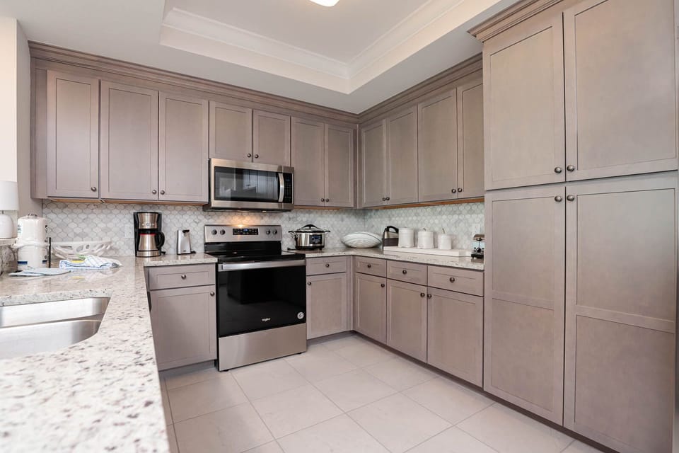 Prepare meals in this kitchen with elegant cabinetry, stainless appliances, and stylish backsplash