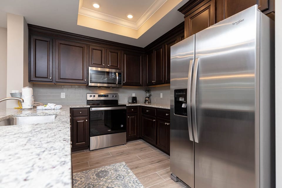 Create memorable meals in the kitchen, surrounded by dark cabinetry and sleek, stainless appliances