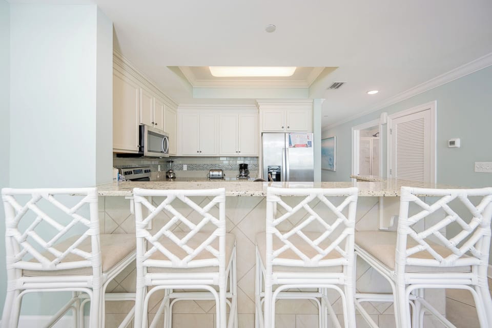 Gather around the inviting counter to sip morning coffee and share laughter in the airy kitchen space