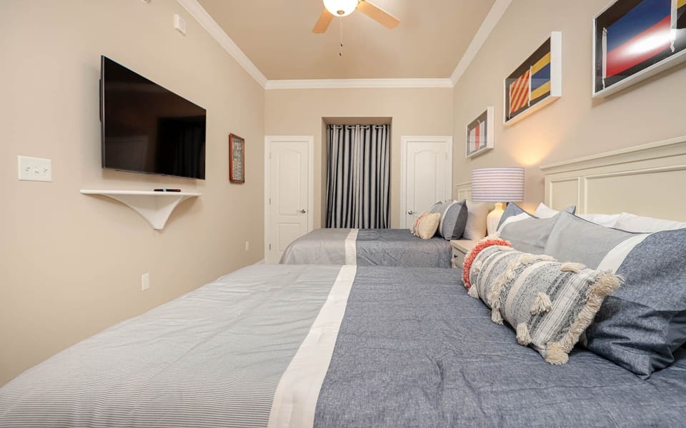 Relax in this guest room with two queen beds, enjoying your favorite shows, surrounded by stylish decor