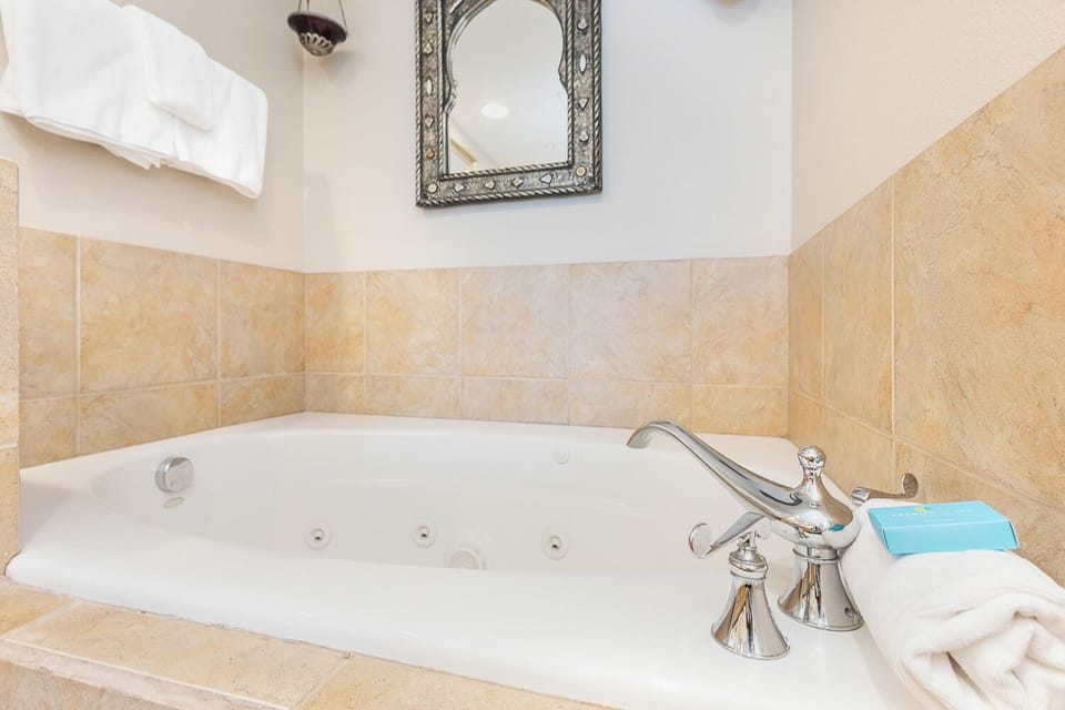 Sink into the whirlpool tub and let your cares melt away. Warm tiles, plush towels, and an ornate mirror set the mood for total relaxation.