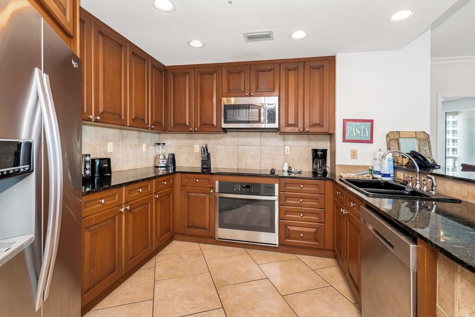 Step into your fully equipped kitchen with warm wood cabinetry, gleaming granite counters, and stainless steel appliances ready for your culinary adventures.