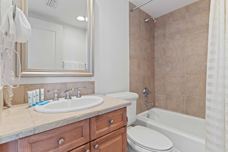 Refresh and recharge in your private bathroom, featuring a tub-shower combo, vanity with classic fixtures, and plush towels ready for your stay.