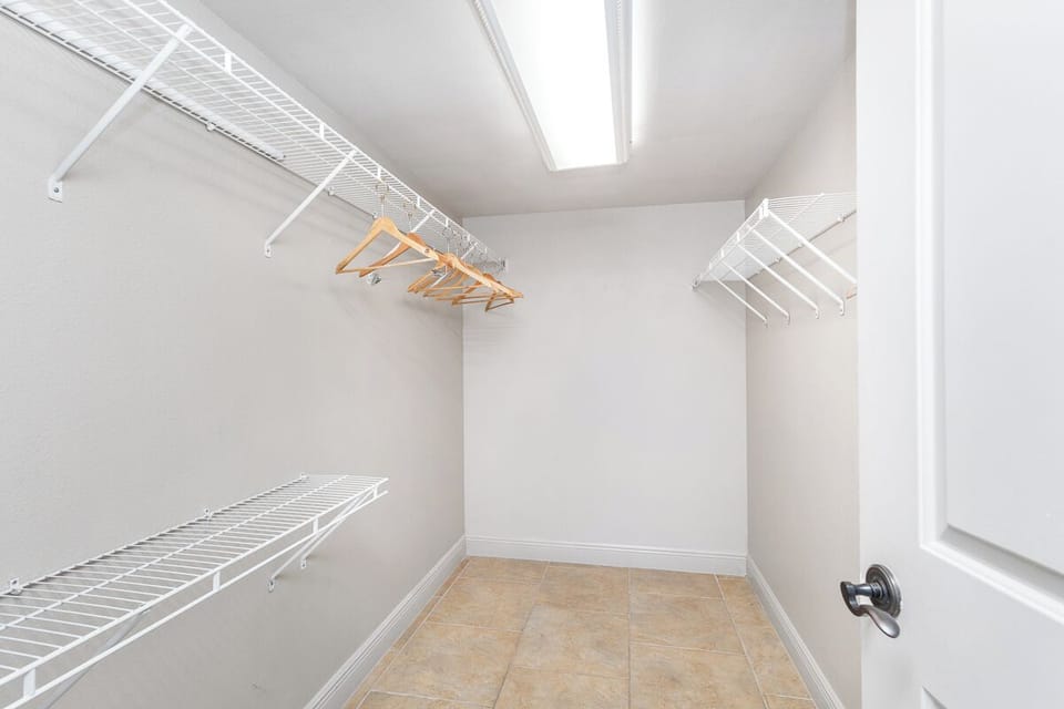 A walk-in closet with wire shelving and hanging space provides plenty of organized storage for all your vacation belongings.