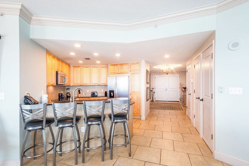 Gather around the spacious breakfast bar in this bright, open kitchen. You'll love the warm wood cabinets, stainless steel appliances, and plenty of room to prepare your favorite meals.