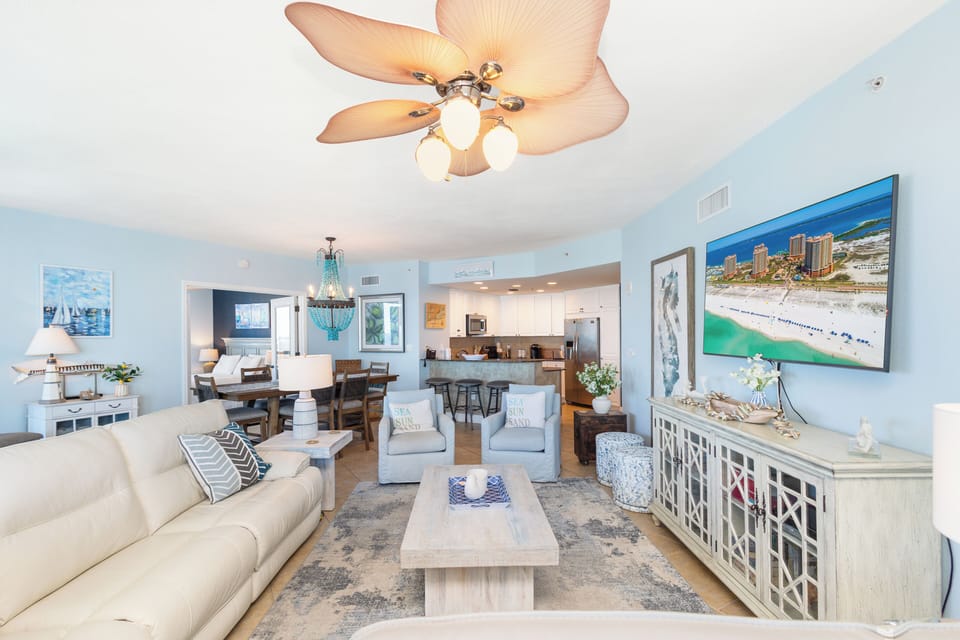 Relax in your beautifully designed open-plan living space, where coastal elegance meets modern comfort with stunning beachfront artwork setting the perfect vacation mood.