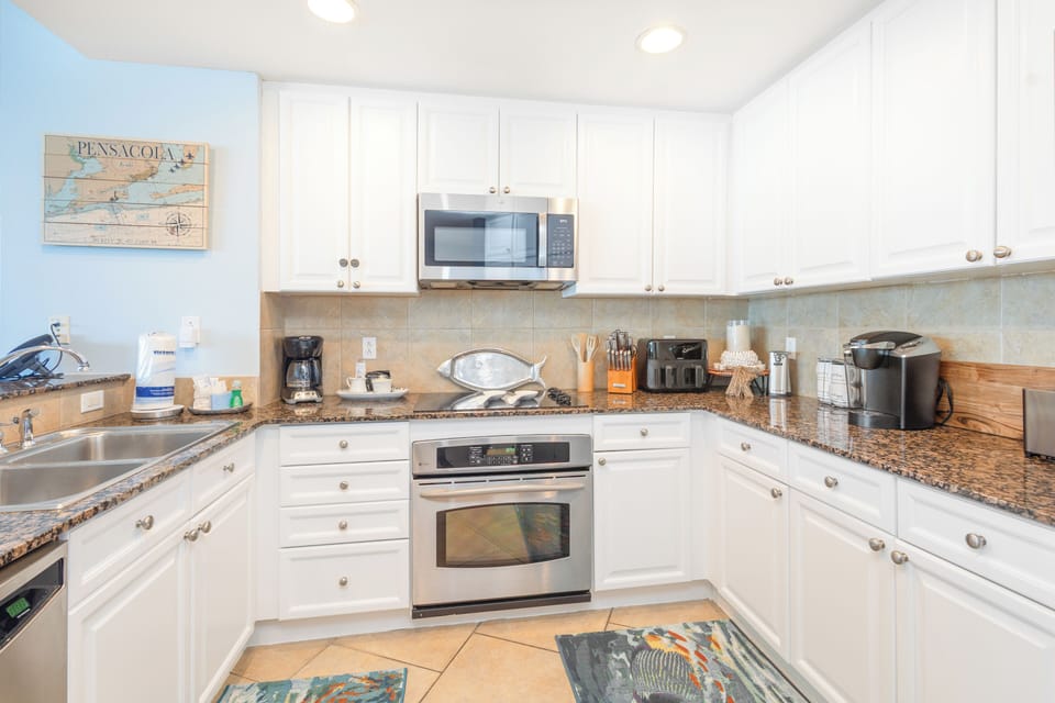 You'll love preparing meals in this bright, fully-equipped kitchen with granite counters, stainless appliances, and coastal charm.