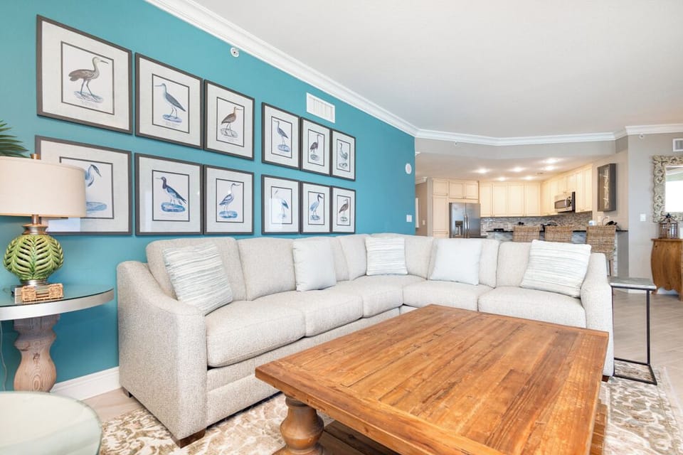 Sink into this plush sectional and feel instantly at home in your coastal retreat. The vibrant teal accent wall and charming bird gallery set a breezy, beachy tone, while the open layout invites you to unwind and connect with your travel companions.
