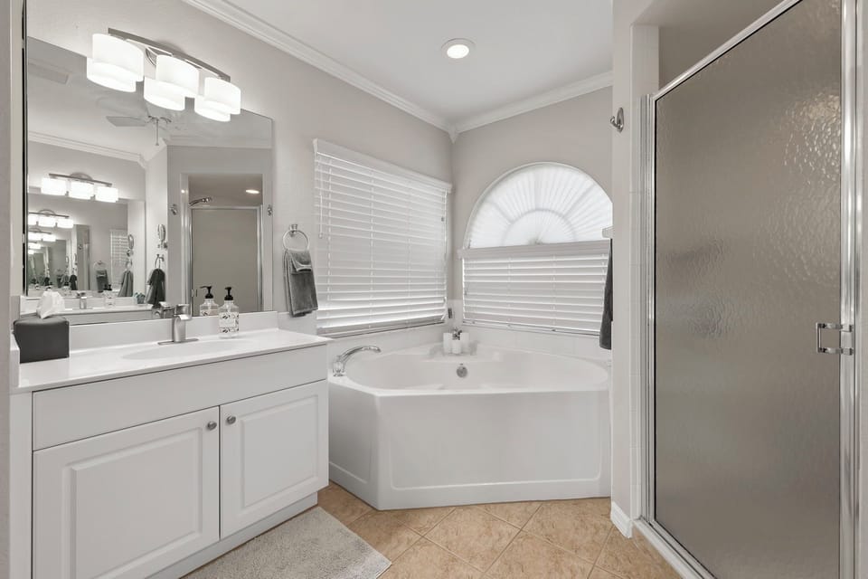 The primary bathroom offers a soaking tub and a separate shower for unwinding after a day in the sun.