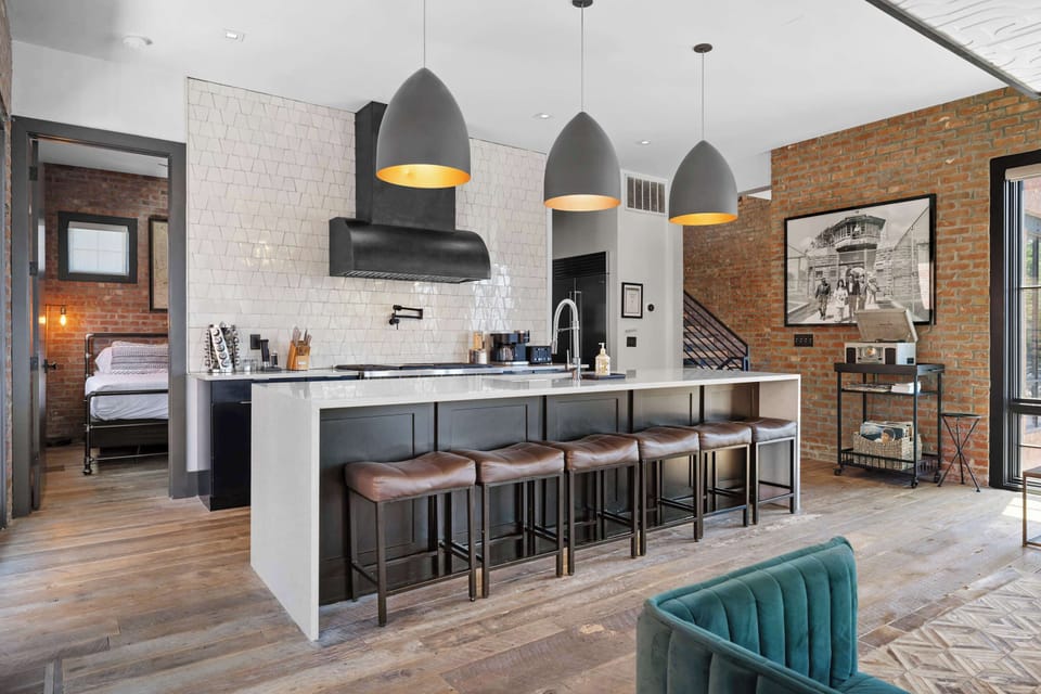 Spacious, fully equipped kitchen featuring a large island with bar seating, stainless steel appliances, coffee station, and plenty of counter space for preparing meals together.

