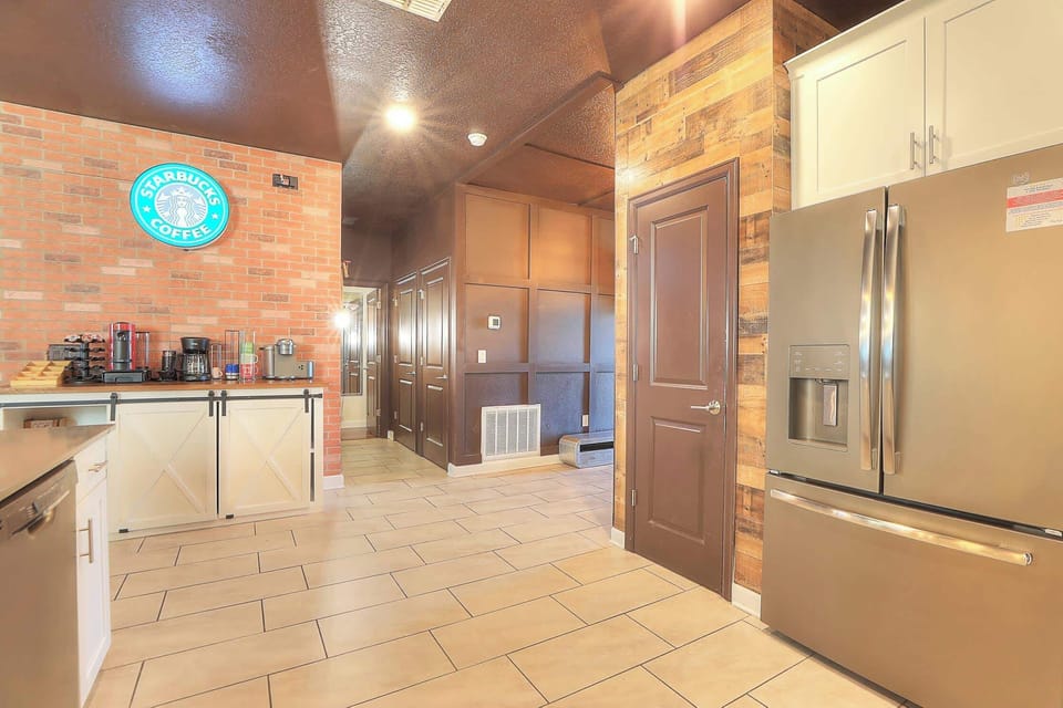 The open-concept kitchen features a Starbucks coffee bar and is fully equipped with dishes, pots, and pans. It includes a complete suite of stainless steel appliances: dishwasher, refrigerator, microwave, stove, oven, air fryer, instant pot and toast