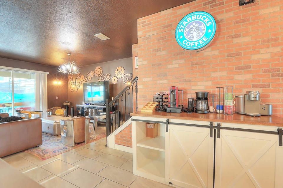 The open-concept kitchen features a Starbucks coffee bar and is fully equipped with dishes, pots, and pans. It includes a complete suite of stainless steel appliances: dishwasher, refrigerator, microwave, stove, oven, air fryer, instant pot and toast