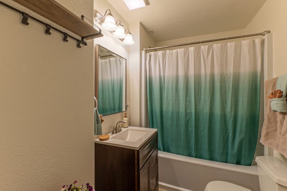 The en suite bath for Bedroom 2 in the south wing has a tub-shower combo.
