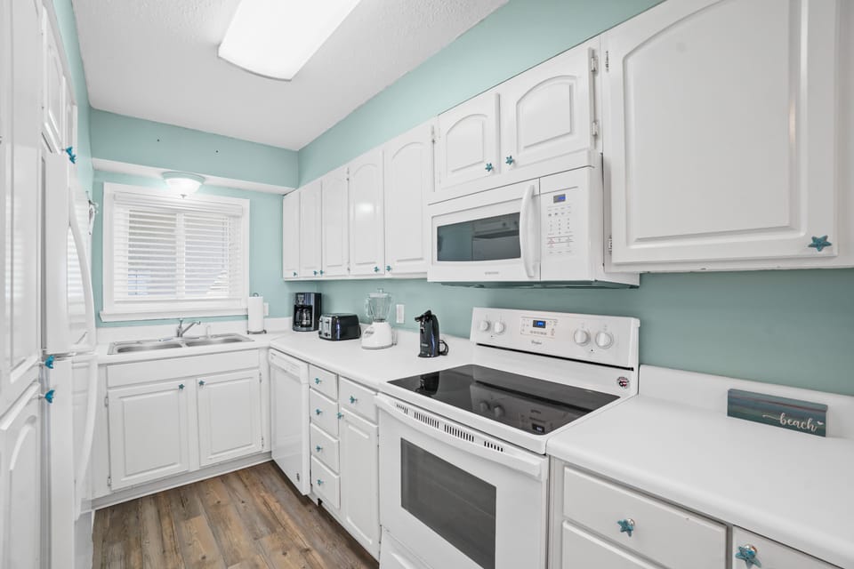 Fully stocked kitchen with stove, oven, microwave, sink, and fridge