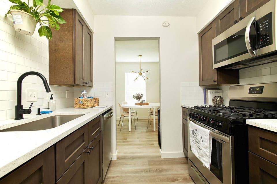 Open-concept kitchen stocked with essentials and an air fryer — prep meals while staying connected to the living space or chatting with friends at the bar stools.