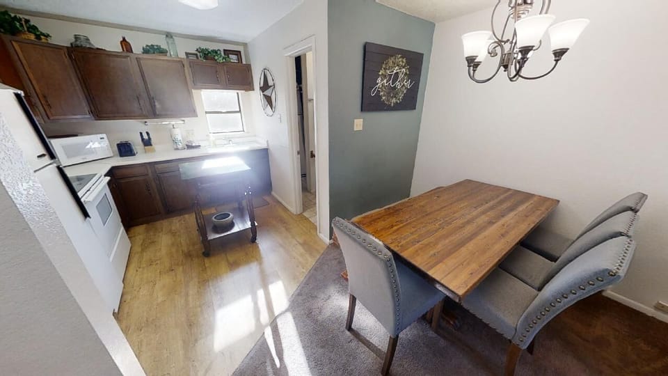 Gather around your handsome wooden dining table for meals and conversation, while the well-equipped kitchen stands ready for all your cooking needs. Warm lighting and coastal-inspired decor create an inviting atmosphere for quality time together.