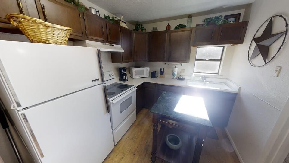 Your fully equipped kitchen features rich wood cabinetry, modern appliances, and ample counter space—perfect for preparing your favorite meals or morning coffee in comfort.